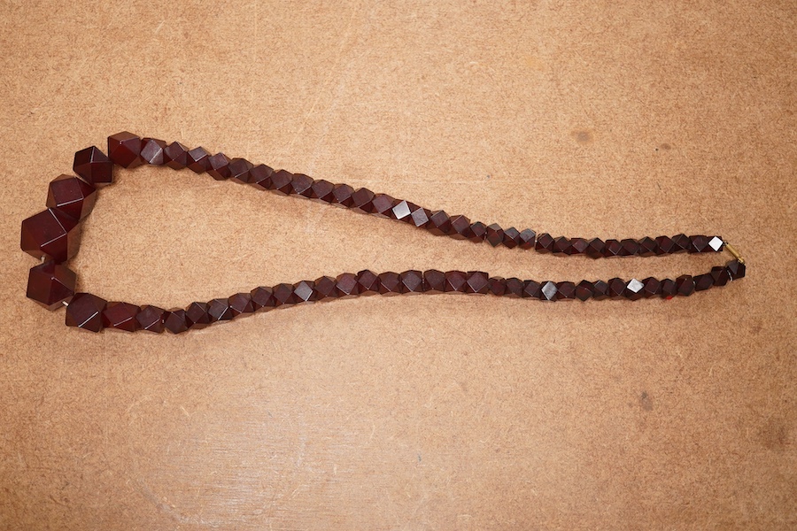 A single strand part facetted simulated cherry amber and part facet paste set necklace, (approx. 30 of the smallest beads are paste), 68cm, gross weight 84 grams. Condition - fair to good